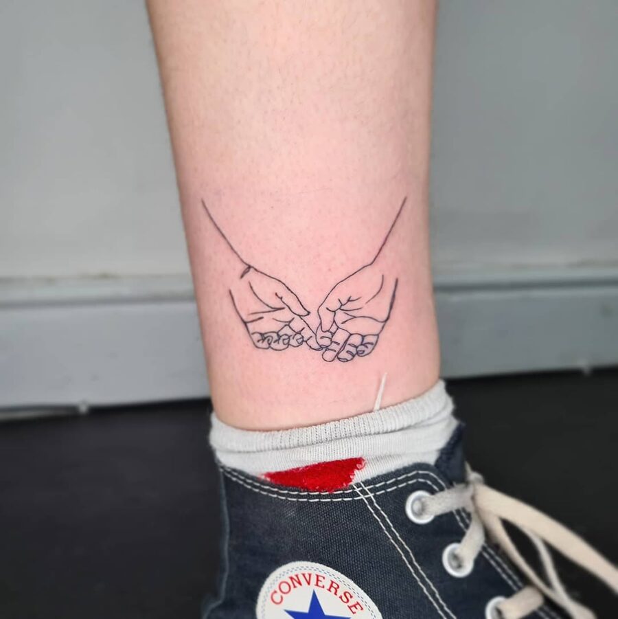 Delicate tattoo of hands intertwining peacefully