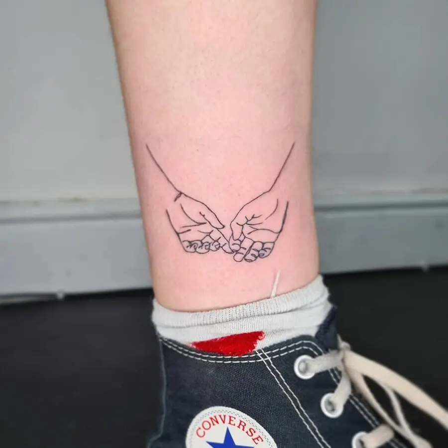 Delicate tattoo of hands intertwining peacefully