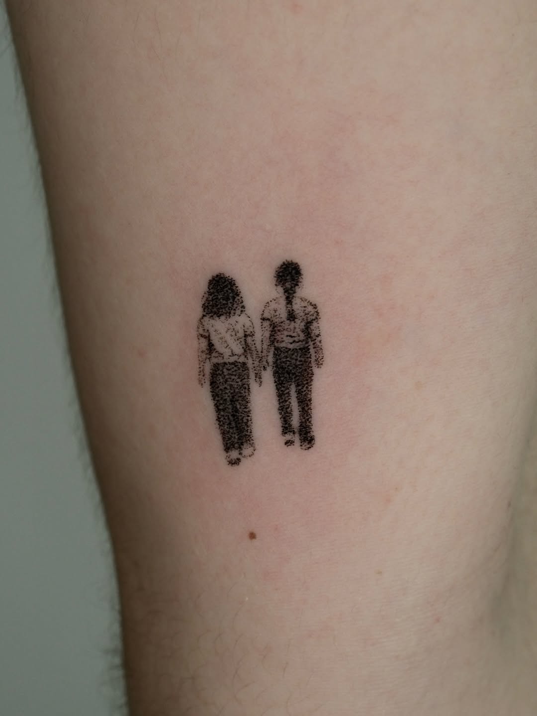 Minimalist holding hands tattoo showcasing connection