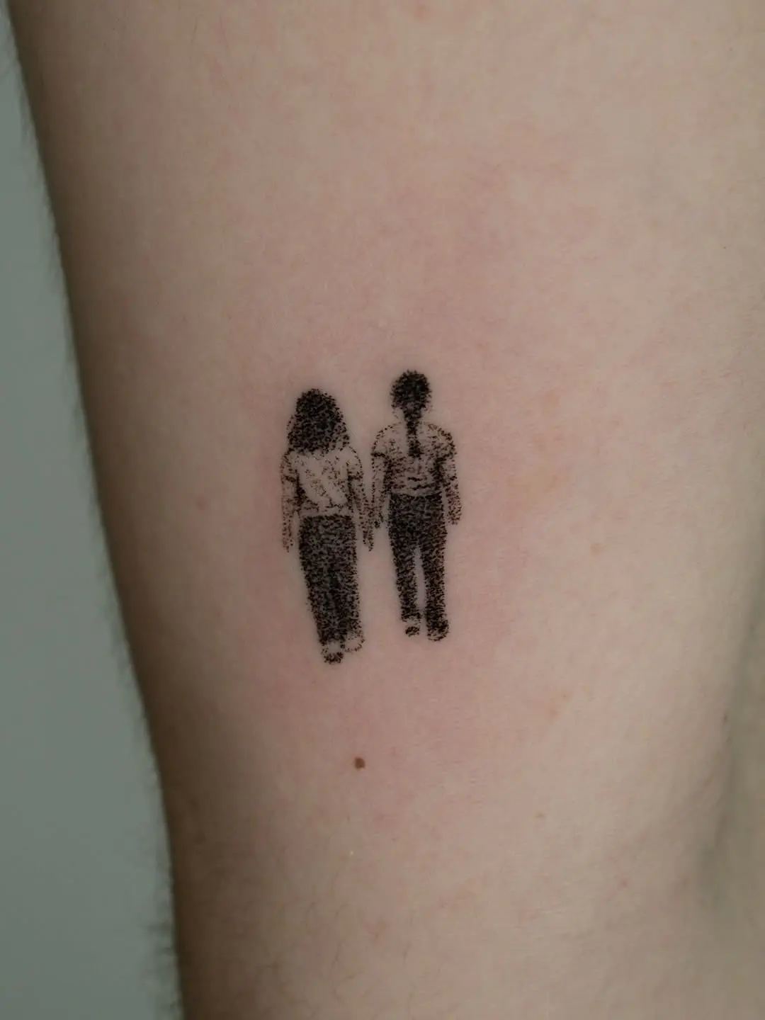 Minimalist holding hands tattoo showcasing connection