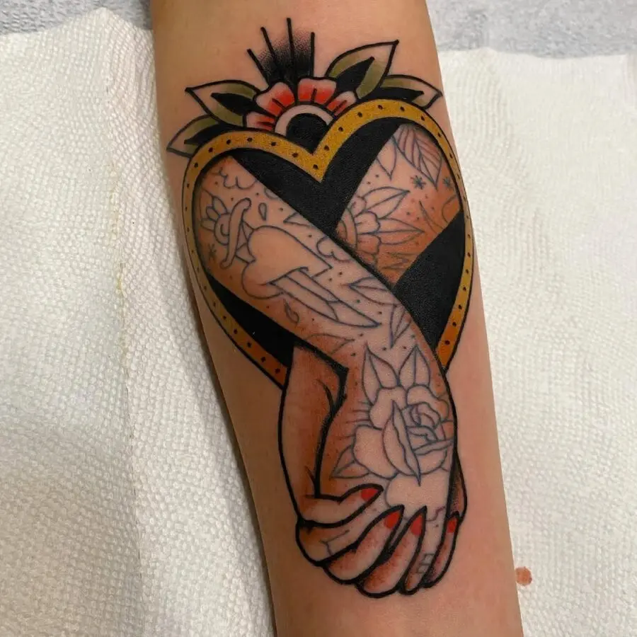 Beautiful heart-shaped holding hands tattoo