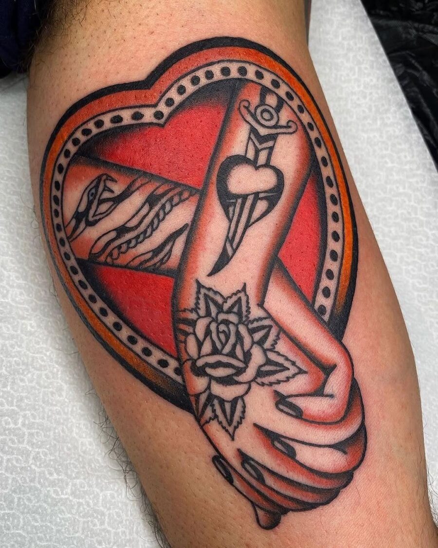 Symbolic holding hands inside a heart tattoo