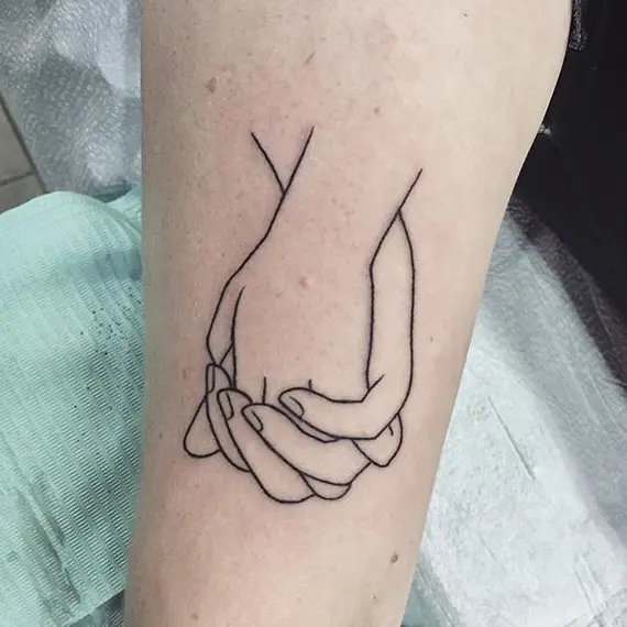 Delicate minimalist hands entwined in ink