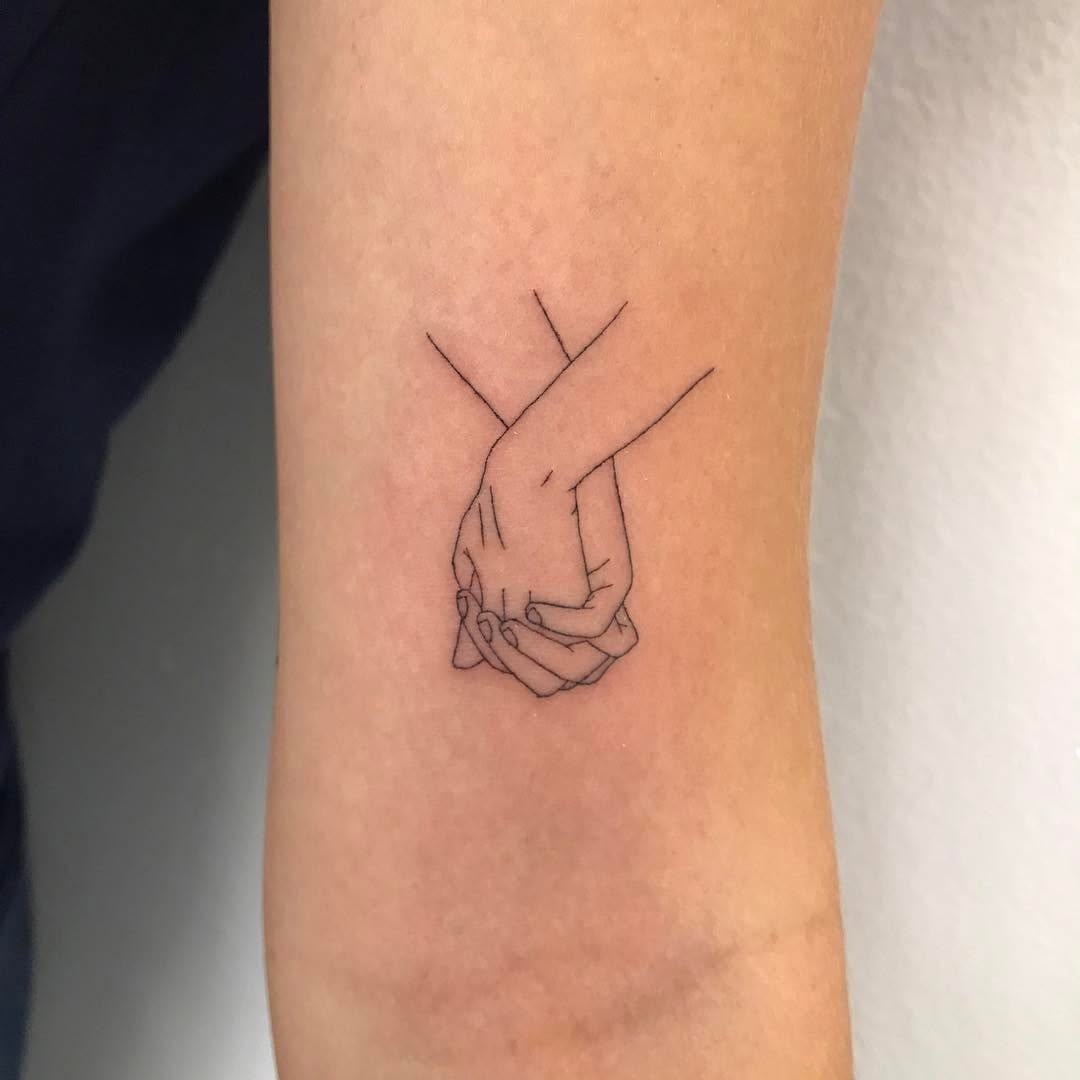 Minimalistic tattoo of intertwined hands design