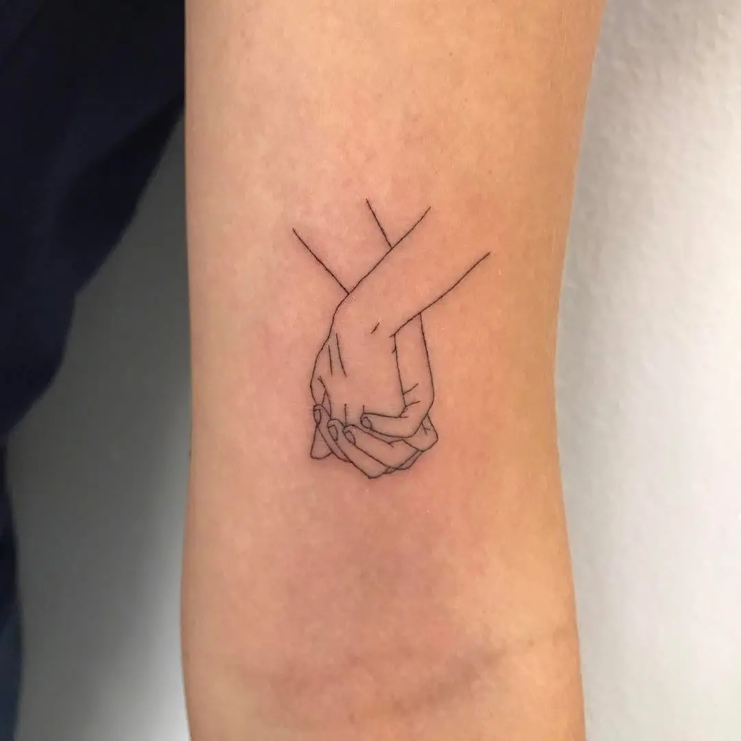 Minimalistic tattoo of intertwined hands design