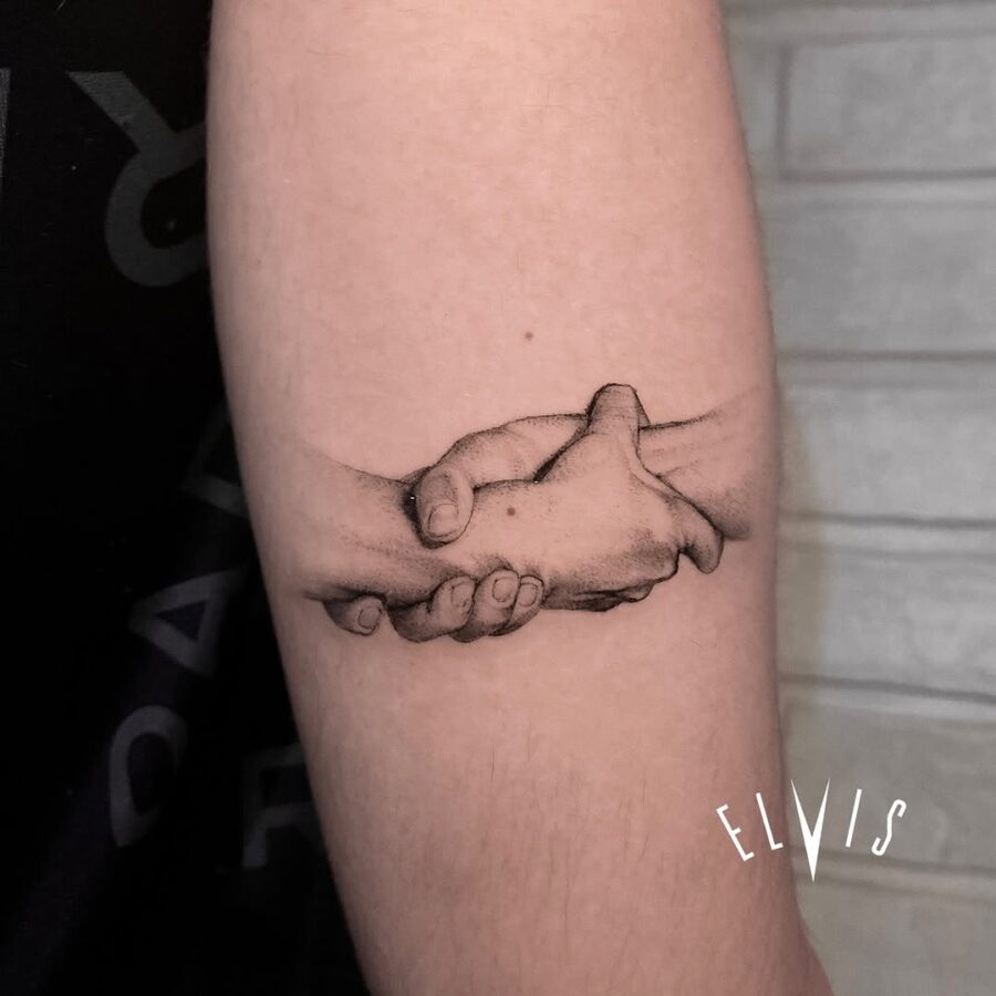 Realistic tattoo of hands clasped together