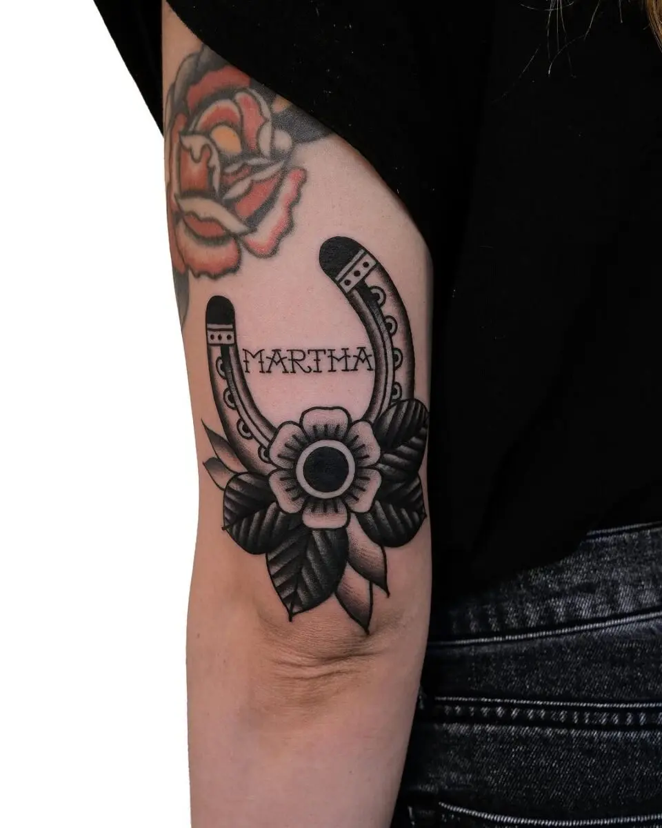 Elegant horseshoe tattoo with floral details