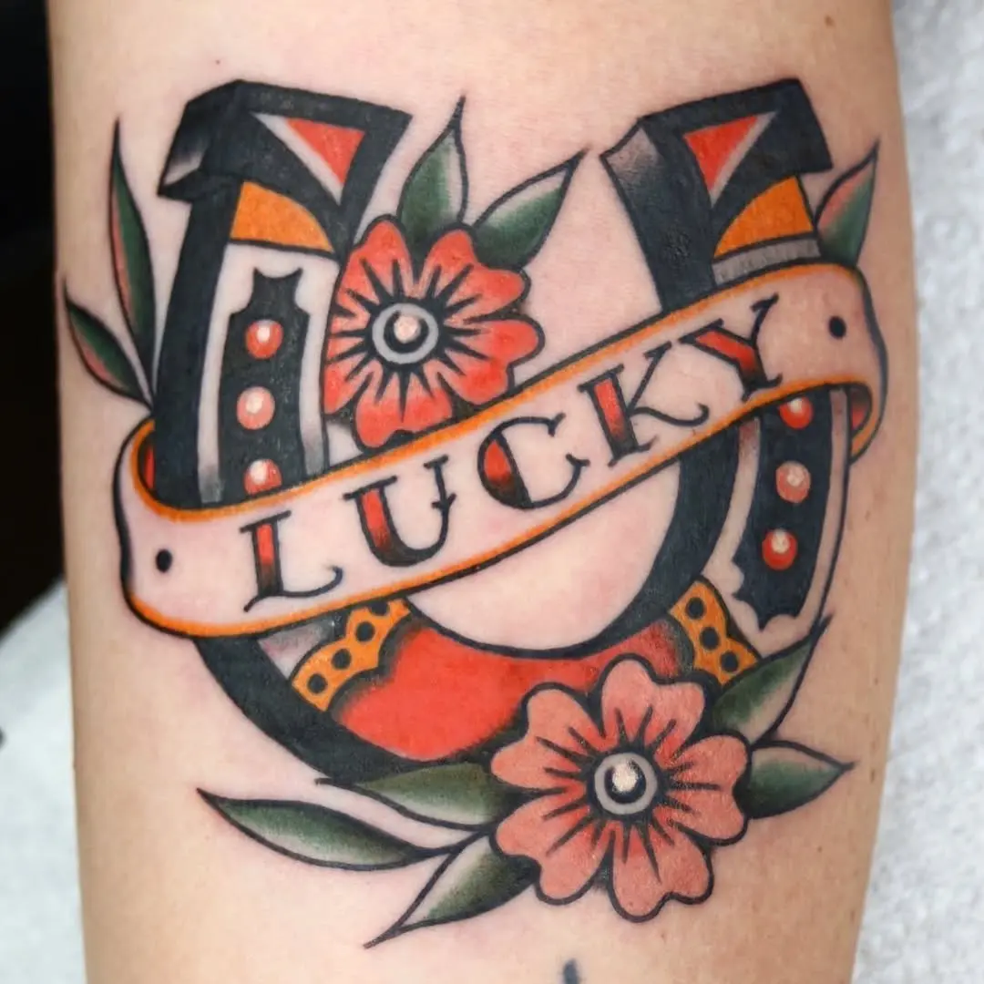 Vibrant horseshoe tattoo with floral elements