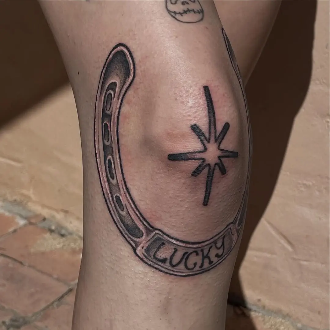 A charming lucky horseshoe tattoo on the knee