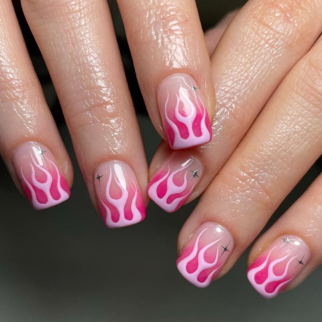 Vibrant hot pink nails with flame art.