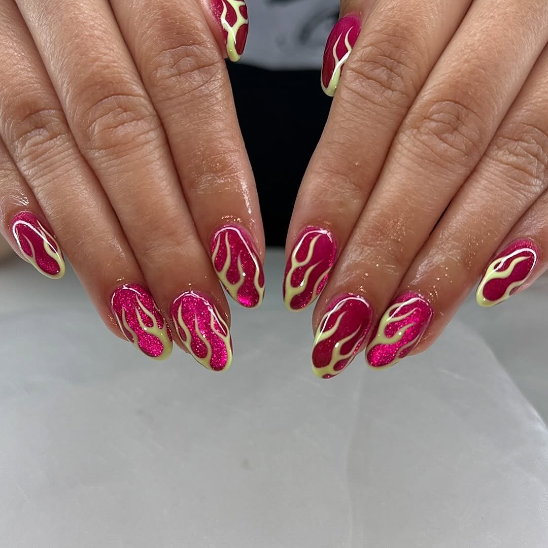 Vibrant hot pink nails with flame accents