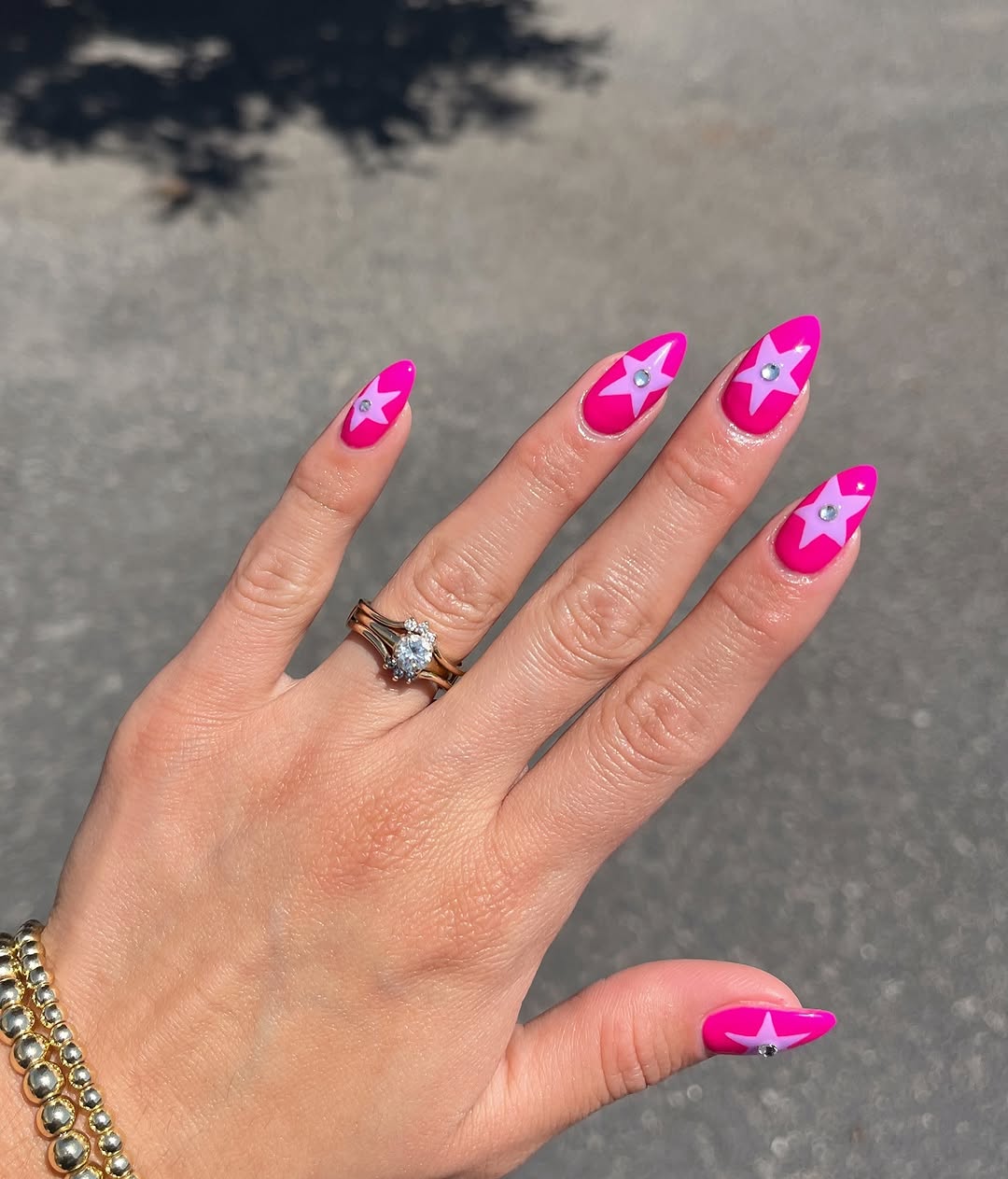 Stylish hot pink nails adorned with stars