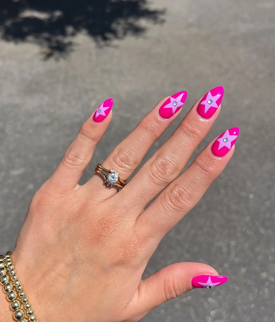 Stylish hot pink nails adorned with stars