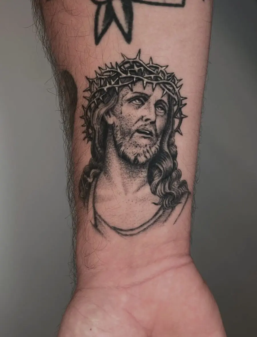 Intricate Jesus portrait tattoo on forearm