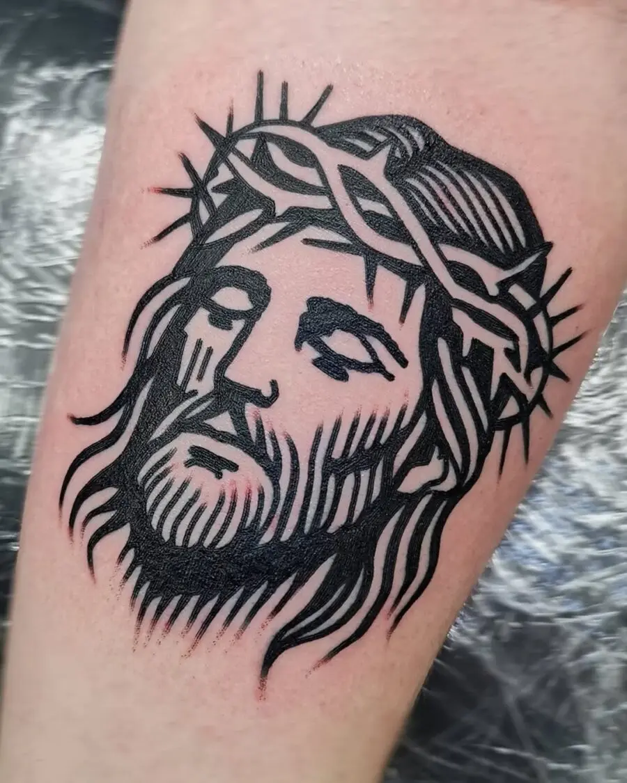 Stylized Jesus portrait in black ink tattoo