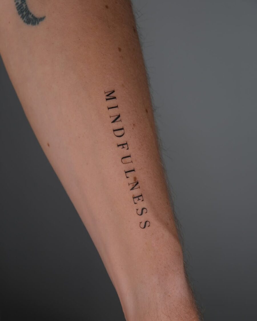 Elegant mindfulness tattoo on forearm