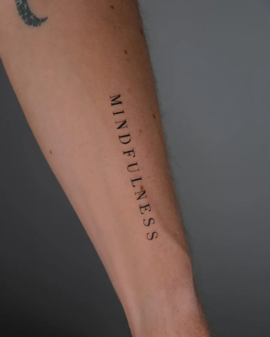 Elegant mindfulness tattoo on forearm