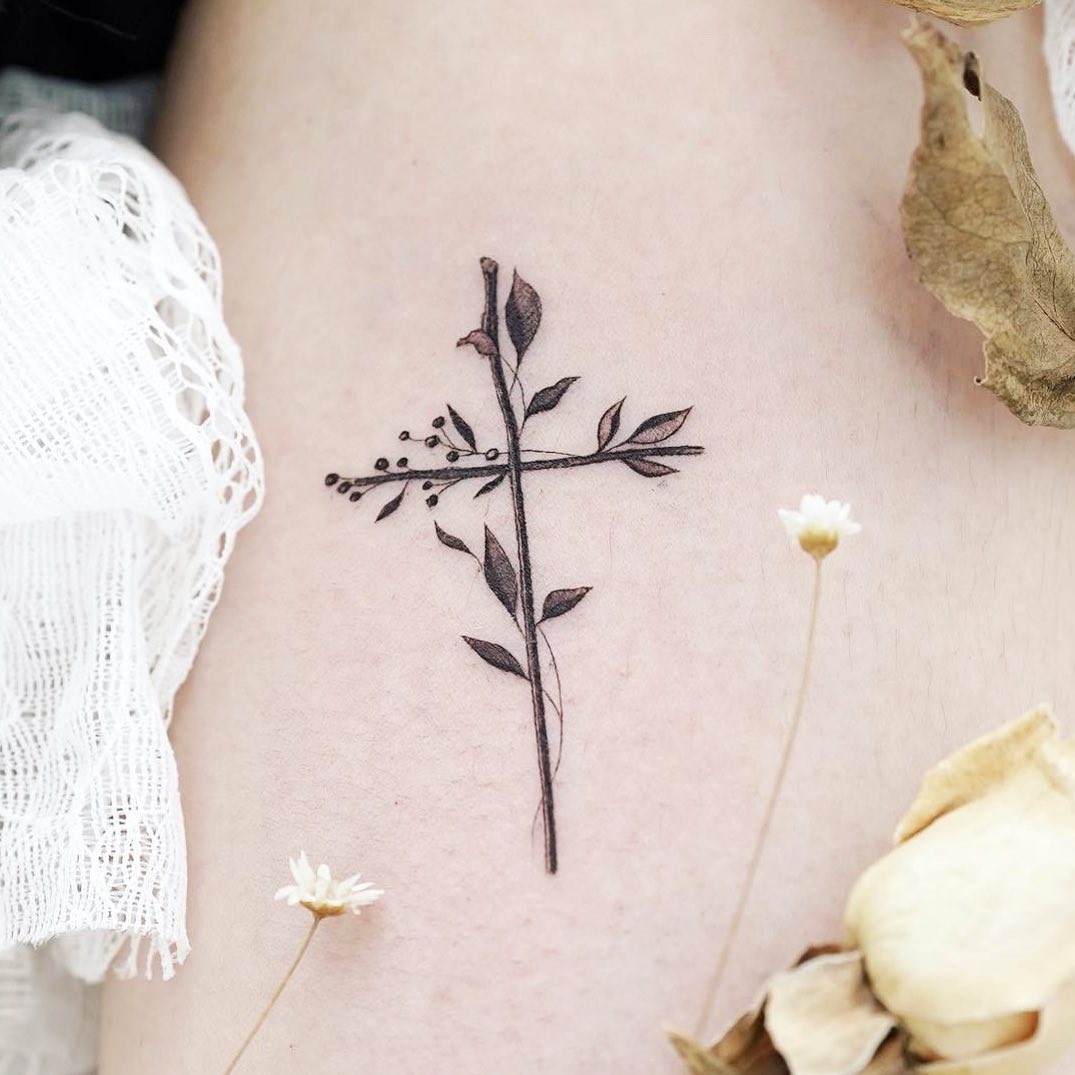 Elegant cross tattoo with delicate floral elements
