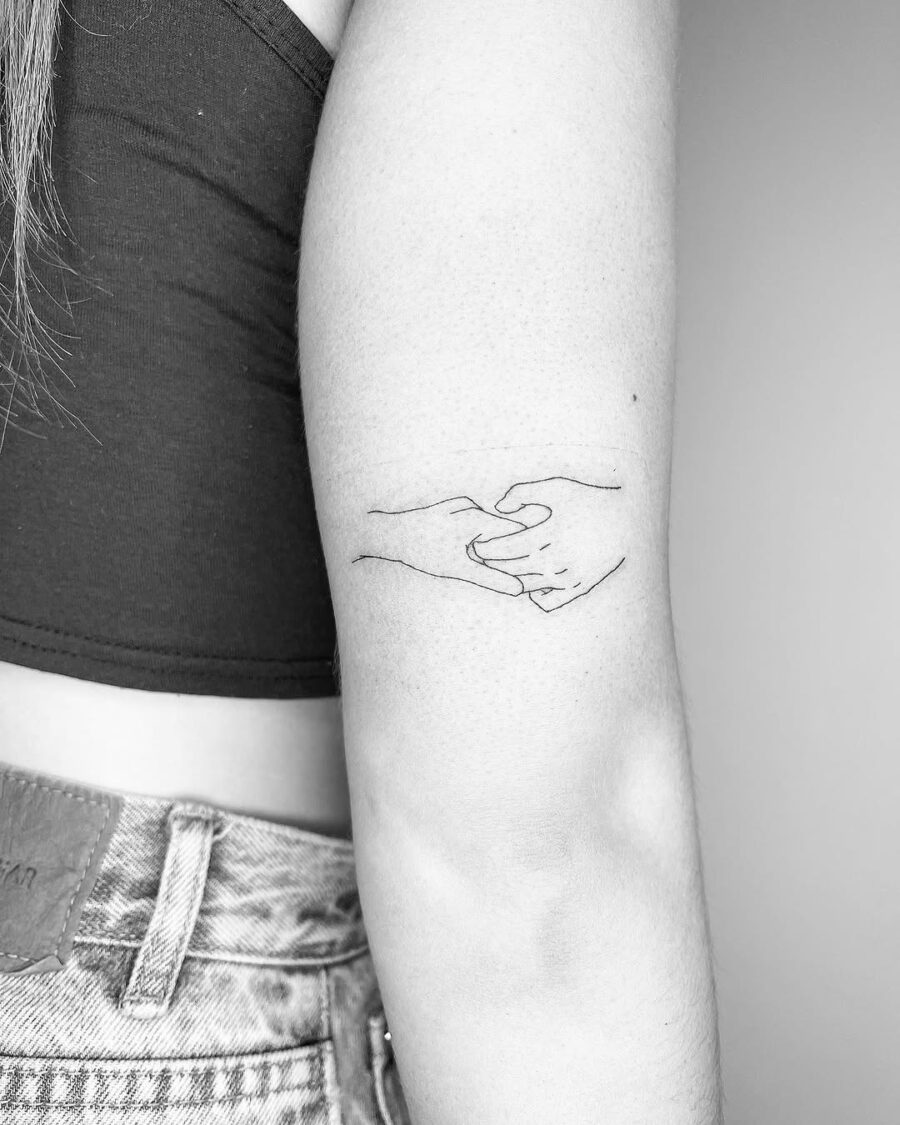 Elegant minimalist tattoo of intertwined hands