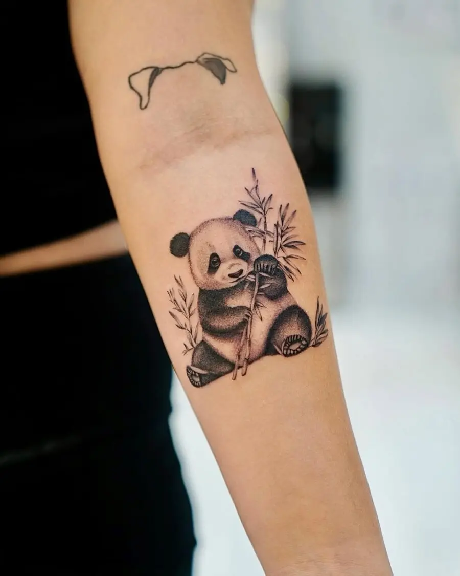 Adorable panda tattoo holding bamboo stalks