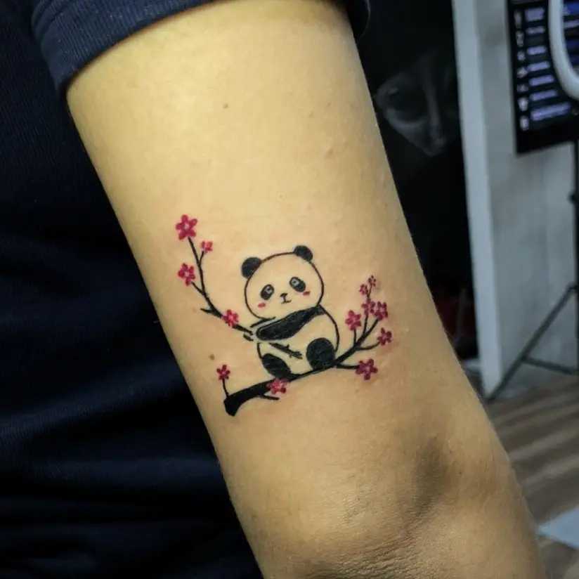 Playful panda perched on cherry blossom branch