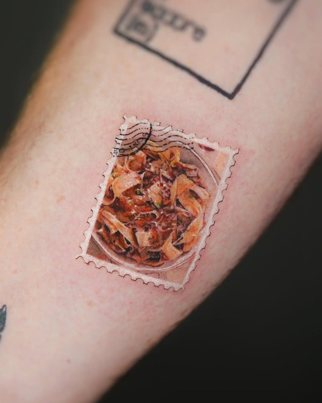 Whimsical pasta tattoo resembling a postage stamp