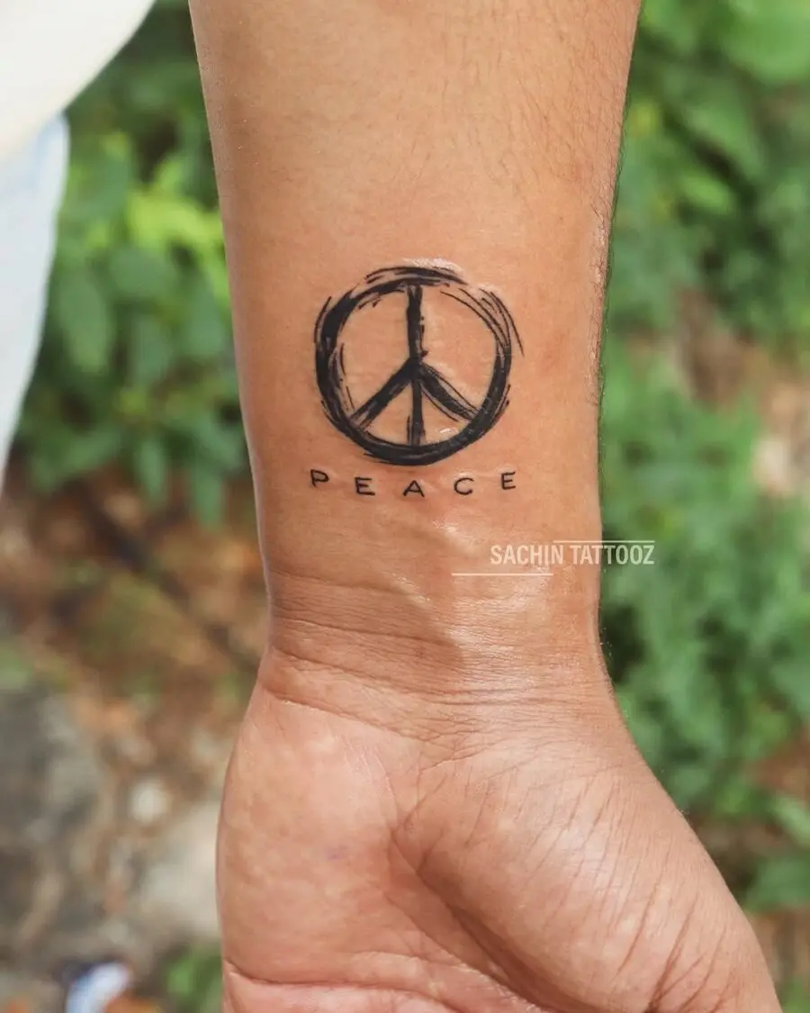Minimalist peace symbol tattoo on wrist