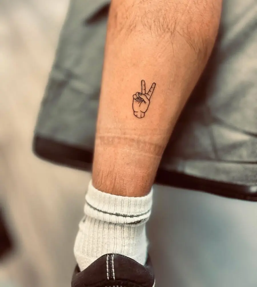 Minimalist peace sign tattoo on inner leg