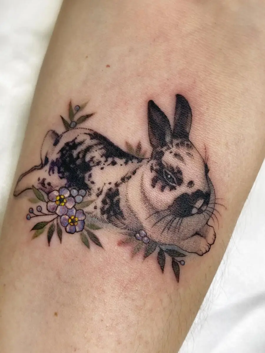 Charming rabbit tattoo with floral accents