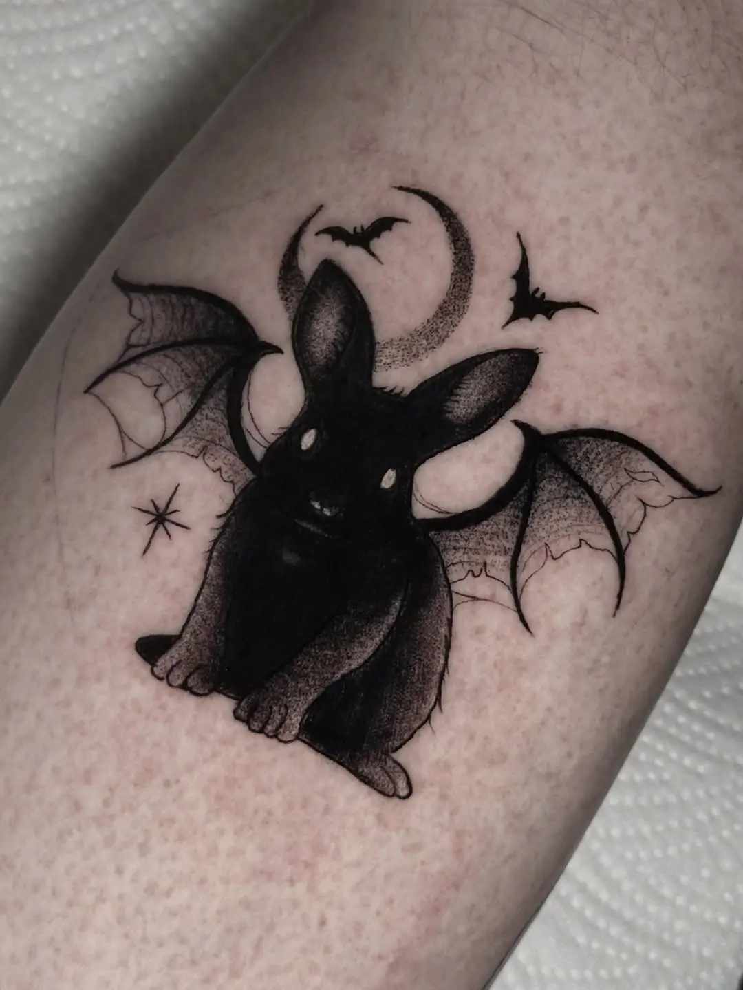 Whimsical rabbit tattoo with bat wings