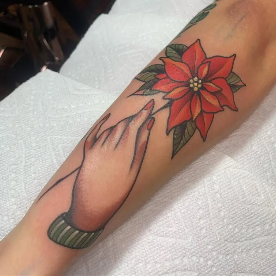 Elegant poinsettia tattoo with hand gesture