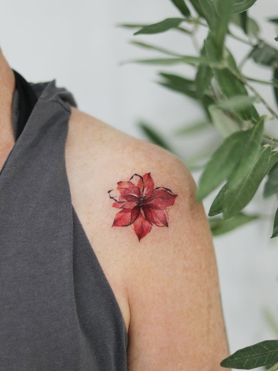 Beautifully vibrant poinsettia inked on shoulder