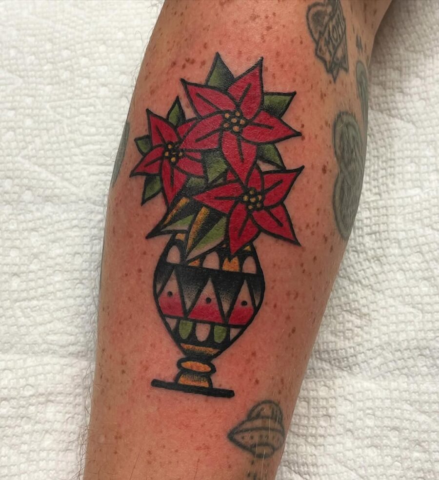 Vibrant poinsettia tattoo in a decorative vase