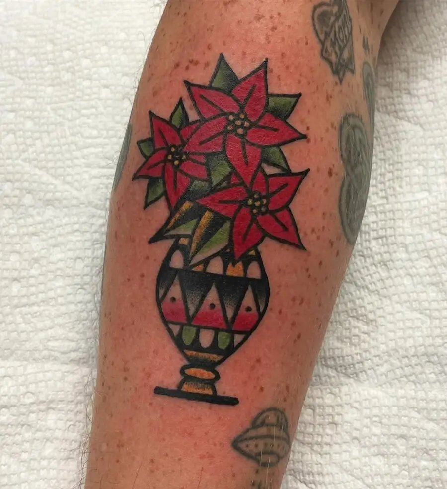 Vibrant poinsettia tattoo in a decorative vase