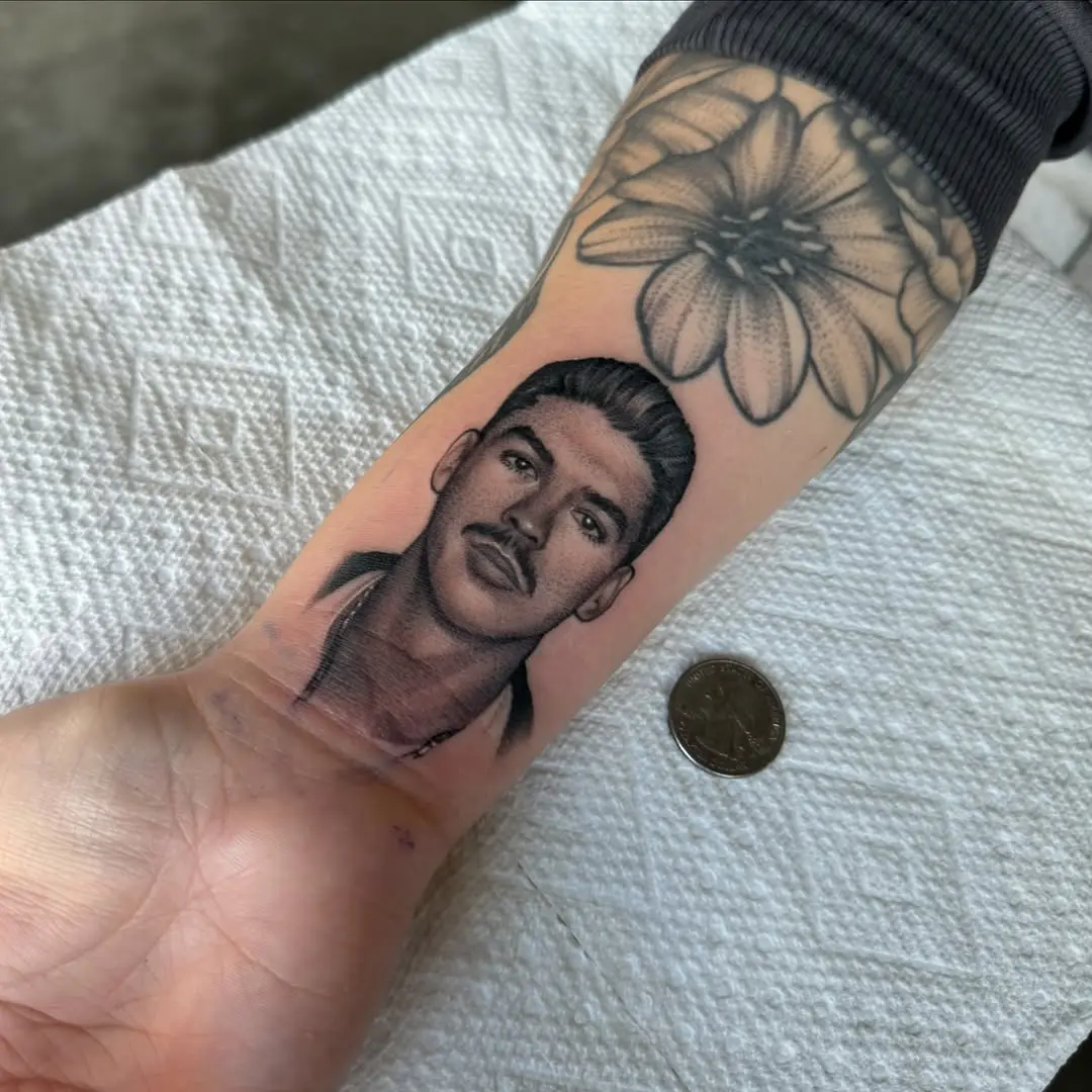 Intricate male portrait tattoo on forearm