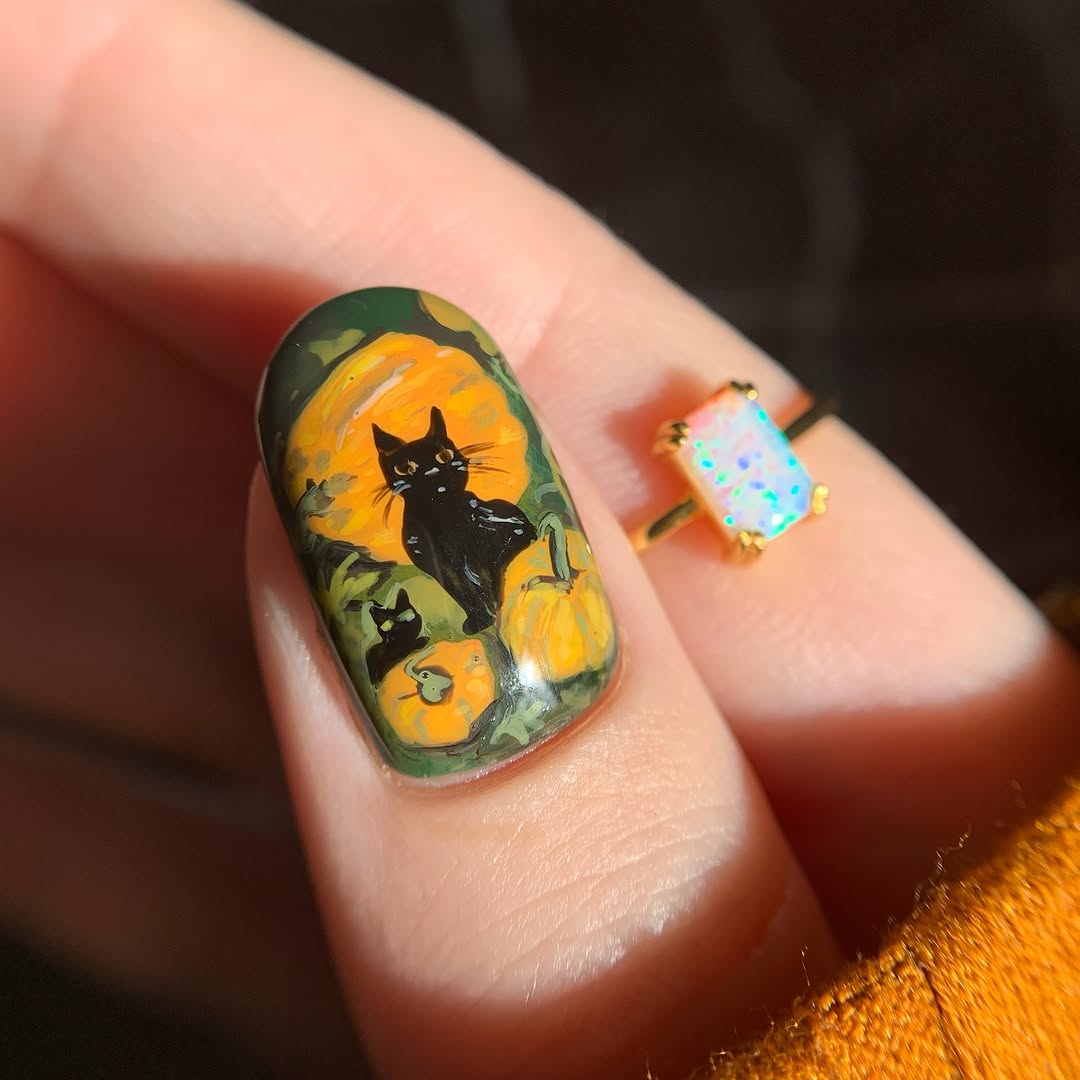 Charming pumpkin nails with a playful black cat