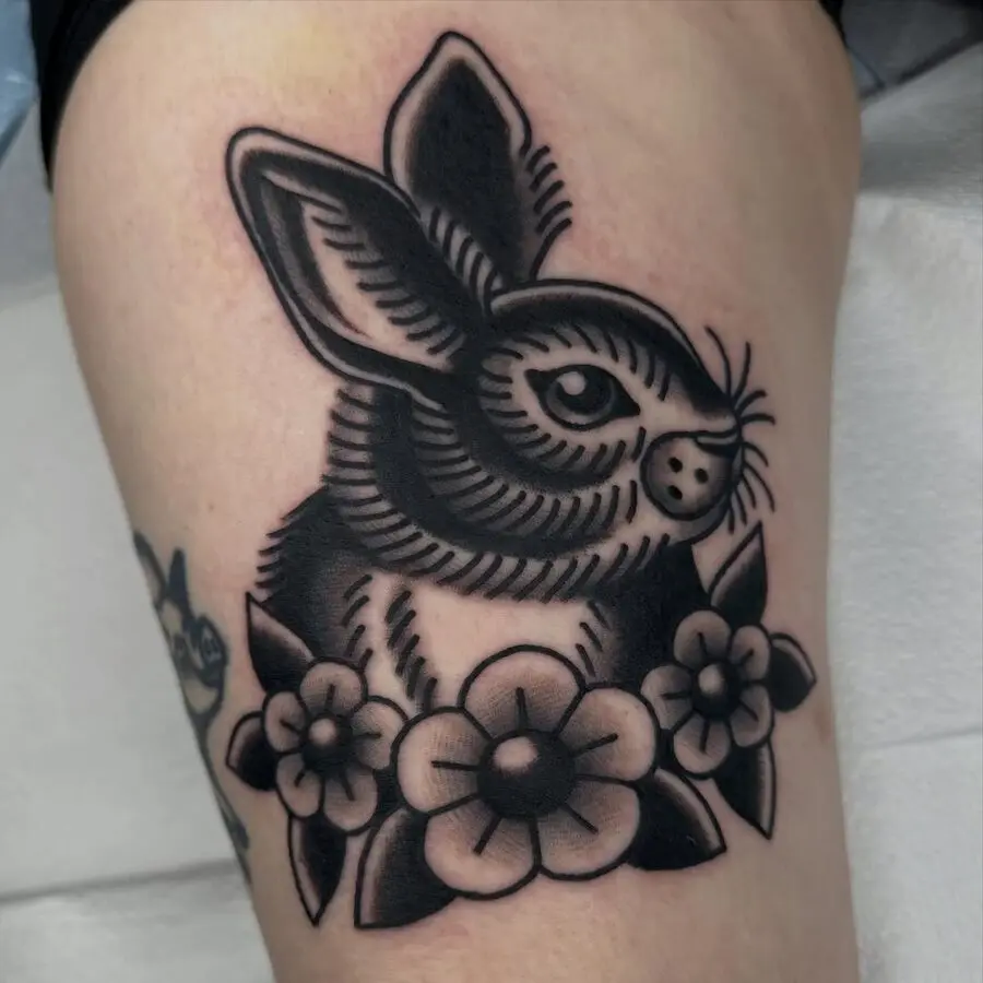 Charming rabbit tattoo surrounded by flowers