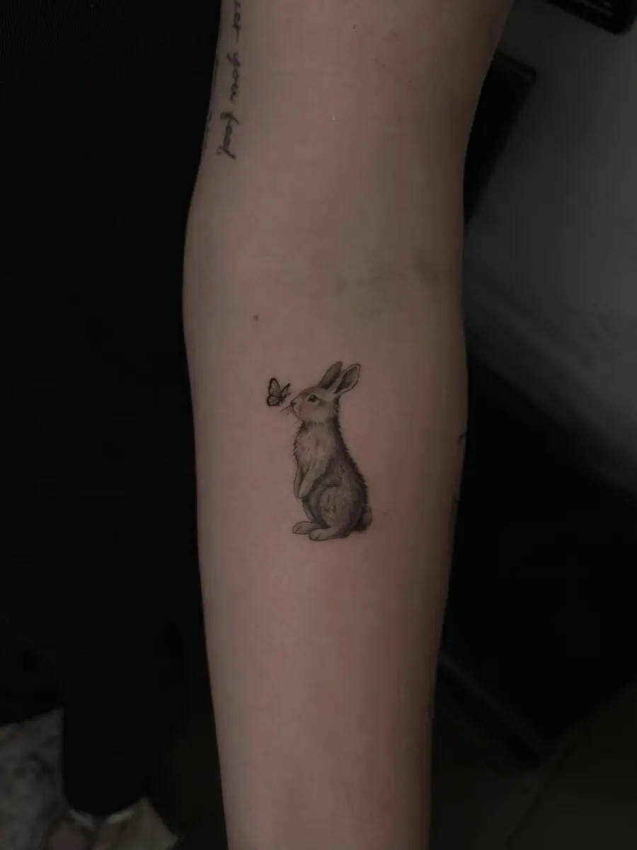 Charming rabbit tattoo with butterfly companion