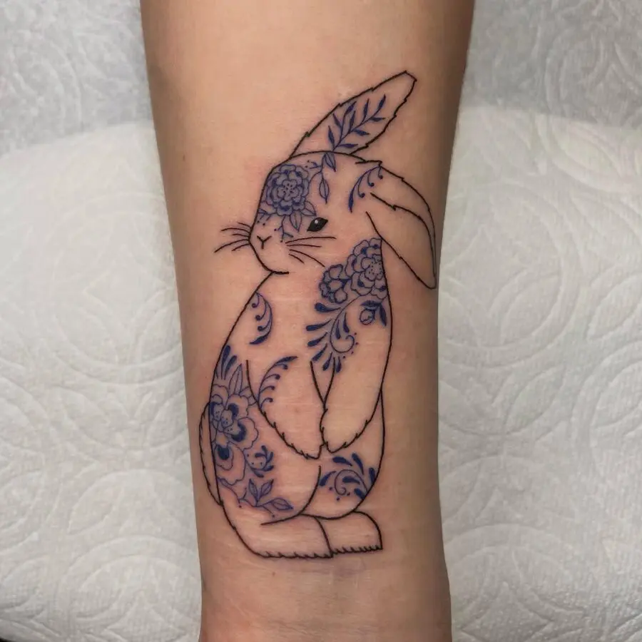 Whimsical rabbit tattoo with floral elements