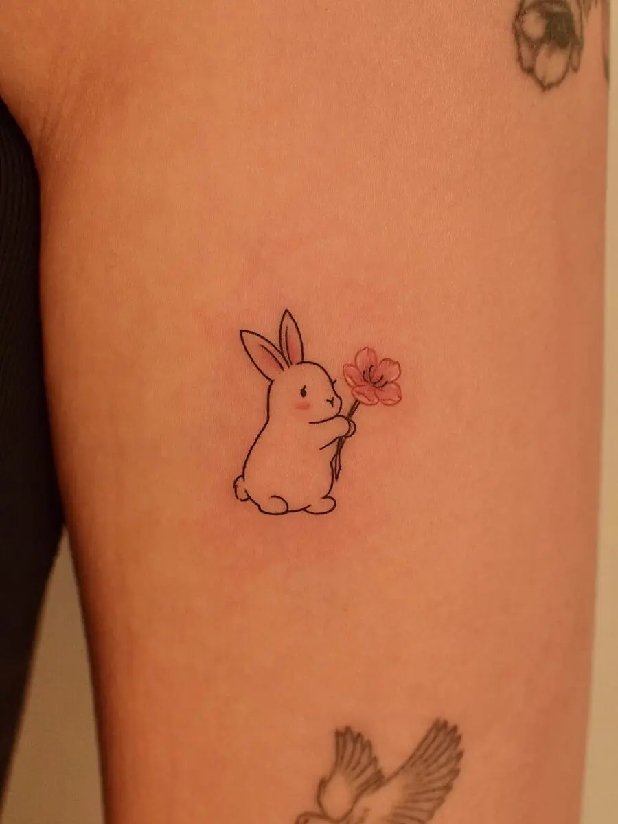 Charming Rabbit Holding a Flower Tattoo Design