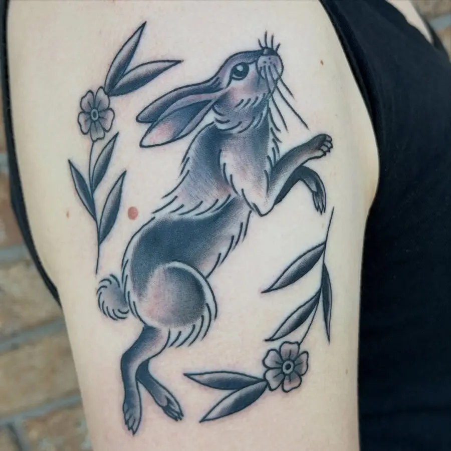 Charming rabbit tattoo with floral accents