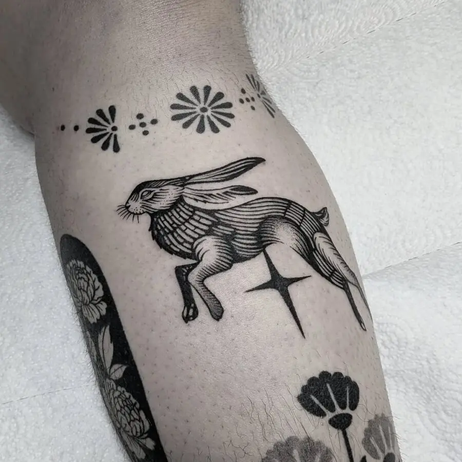 Elegant leaping rabbit tattoo in black ink