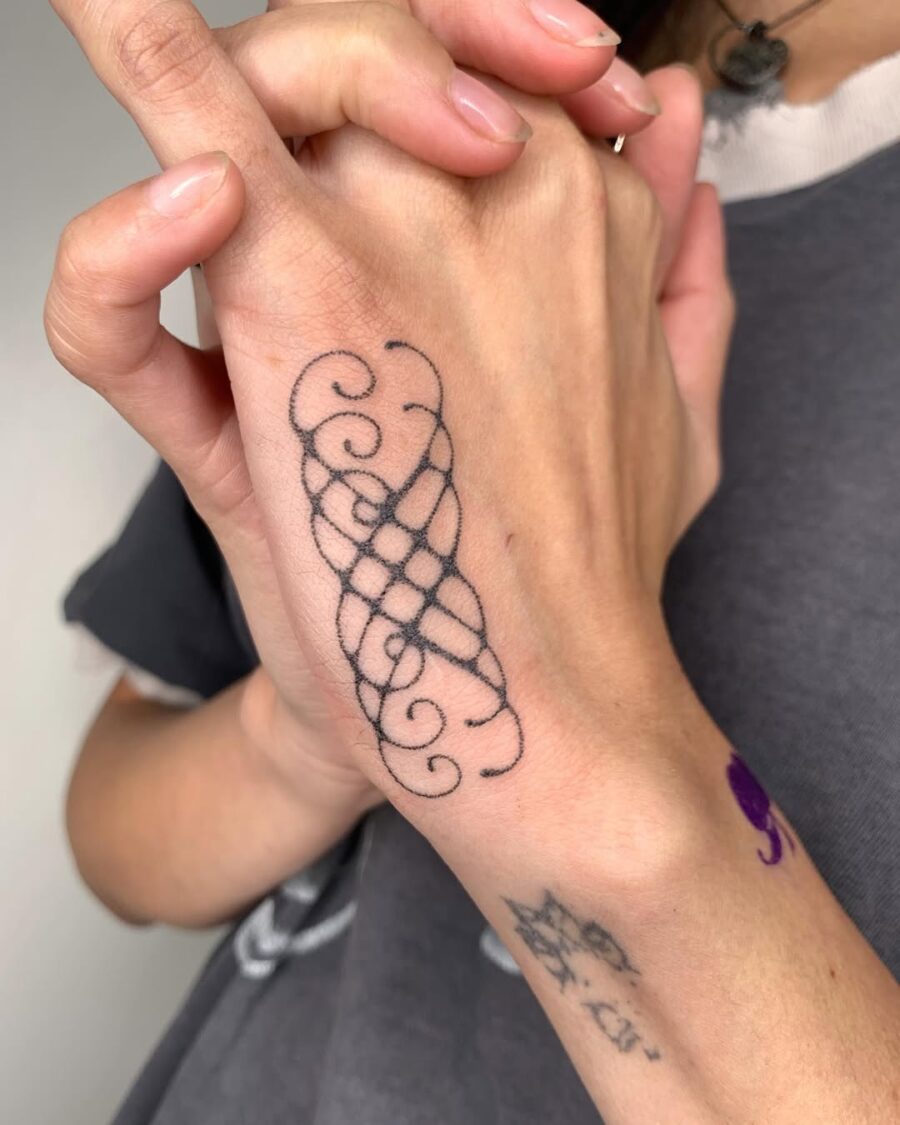 Elegant intricate swirl side hand tattoo