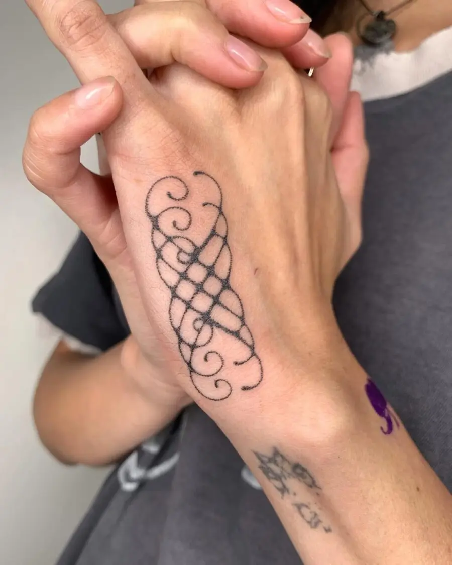 Elegant intricate swirl side hand tattoo