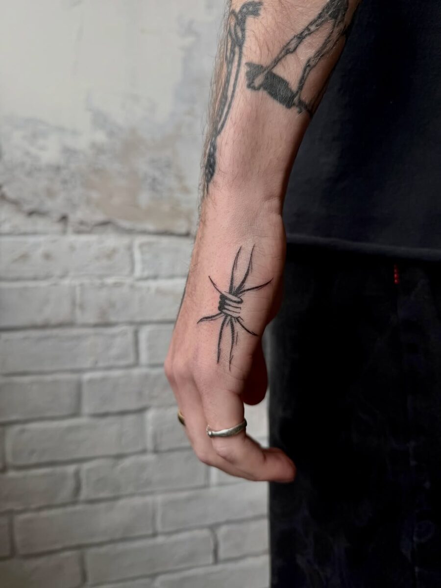 Stylish knotted tattoo on side of hand