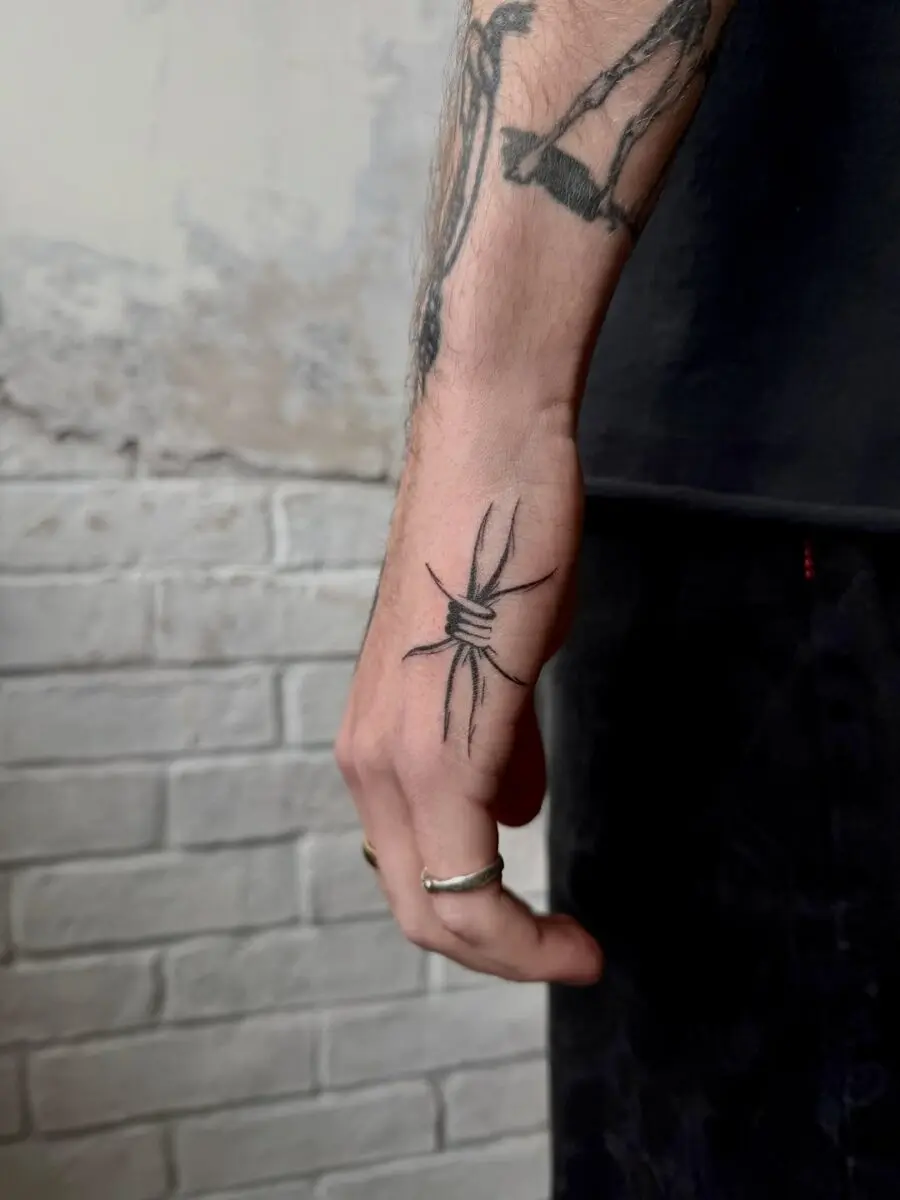 Stylish knotted tattoo on side of hand