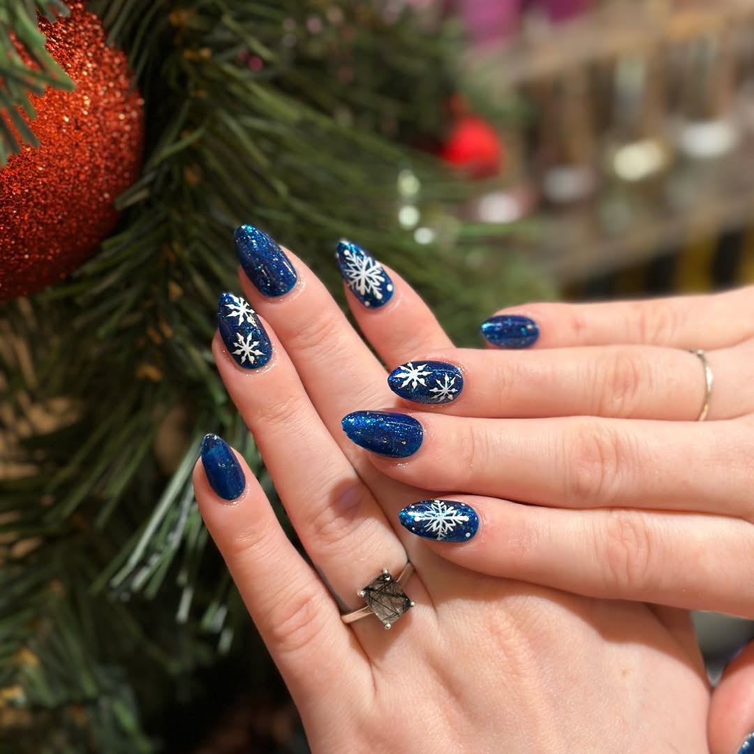 Charming snowflake design on festive blue nails