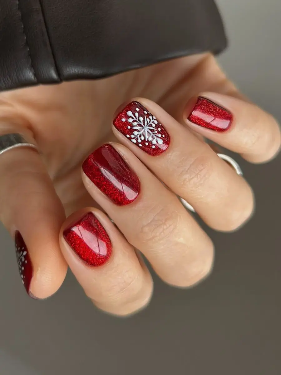 Gorgeous red nails adorned with snowflake designs