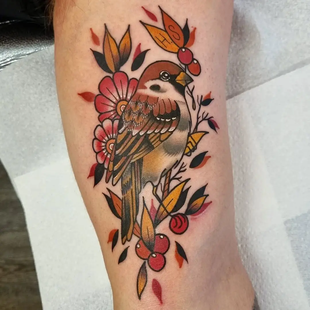 Vibrant sparrow tattoo with floral accents