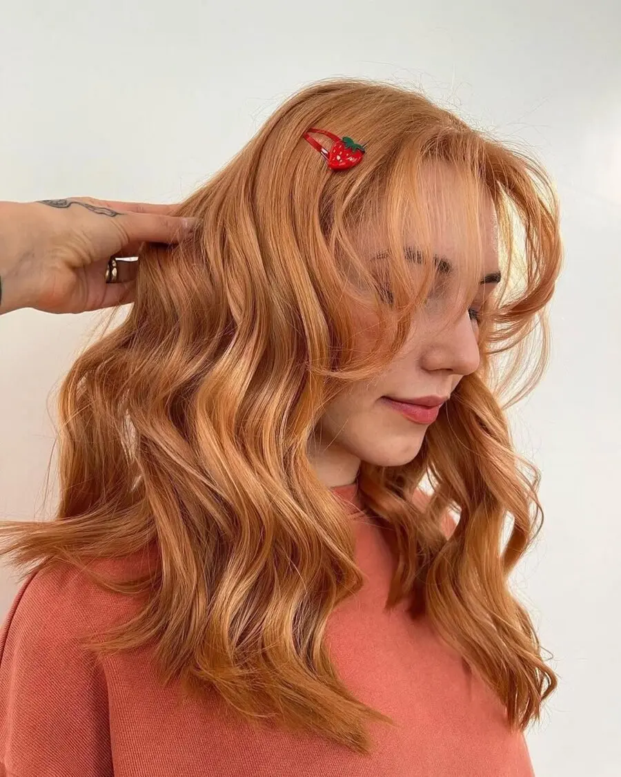 Chic strawberry blonde waves with playful clip